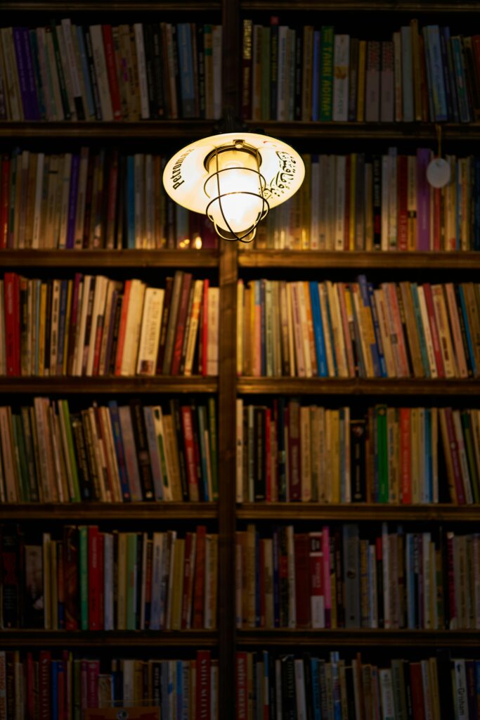 A lone light illuminates an old bookcase.