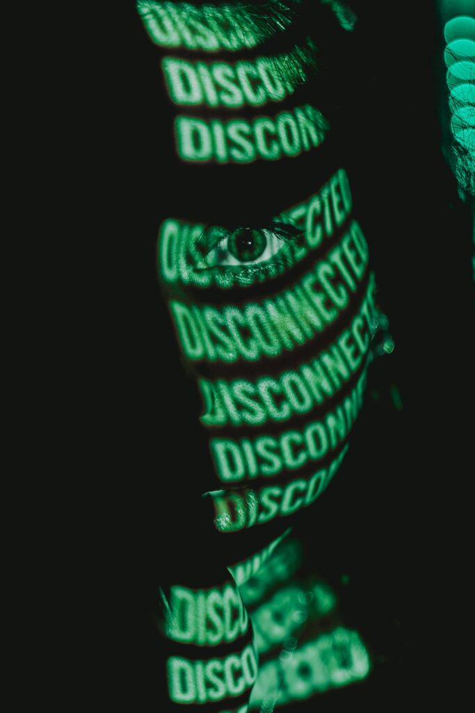 A woman’s face is covered in sickly green text reading “disconnected.”