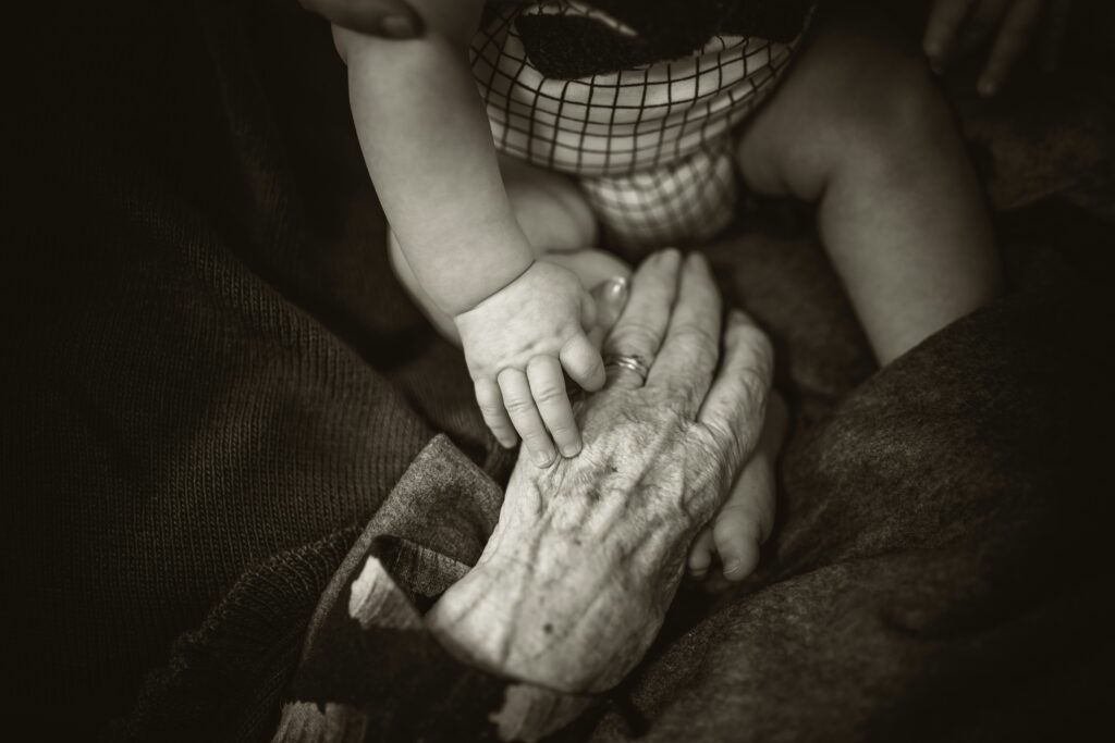 Image of a grandparent holding a small grandchild’s hand.