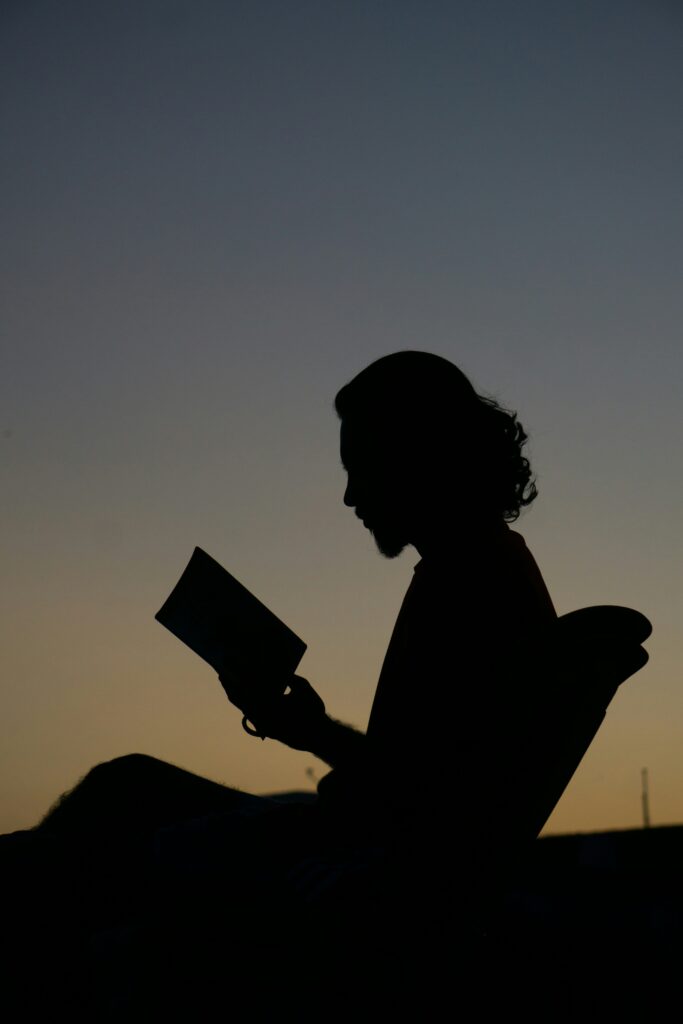 A young reader silhouetted against the sunset.