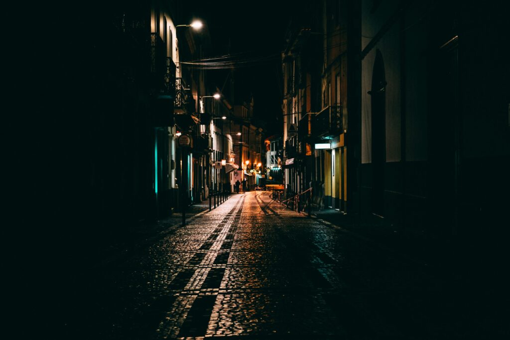 Image of a darkened city street with street lights.