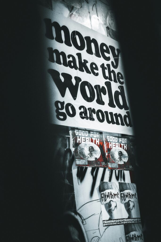A sign reads “money makes the world go around”