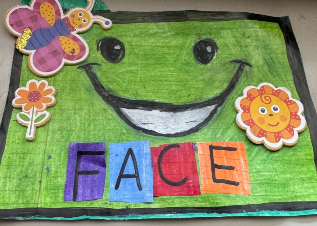 Mixed-media art with a green character that has an overly enthusiastic expression, and a tone that is fear-inducing. There is writing beneath his grin which reads: "FACE" in colorful blocks.