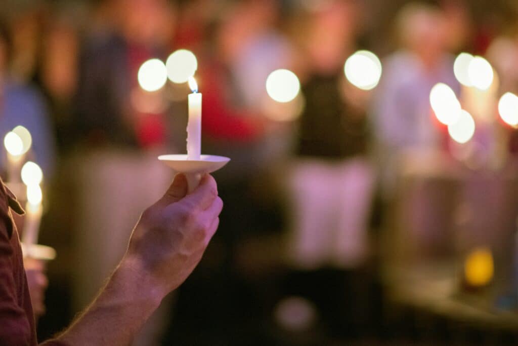 Image of a person holding a candle during a vigil.