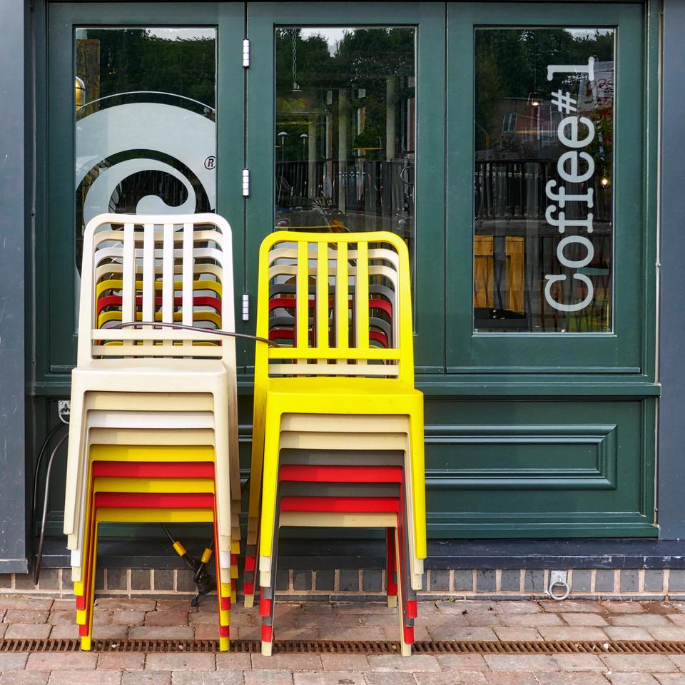 Stacked chairs in front of a café.