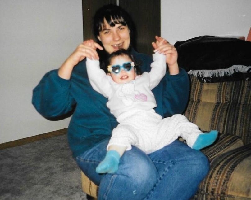 A young child sitting on their mother’s lap. 
