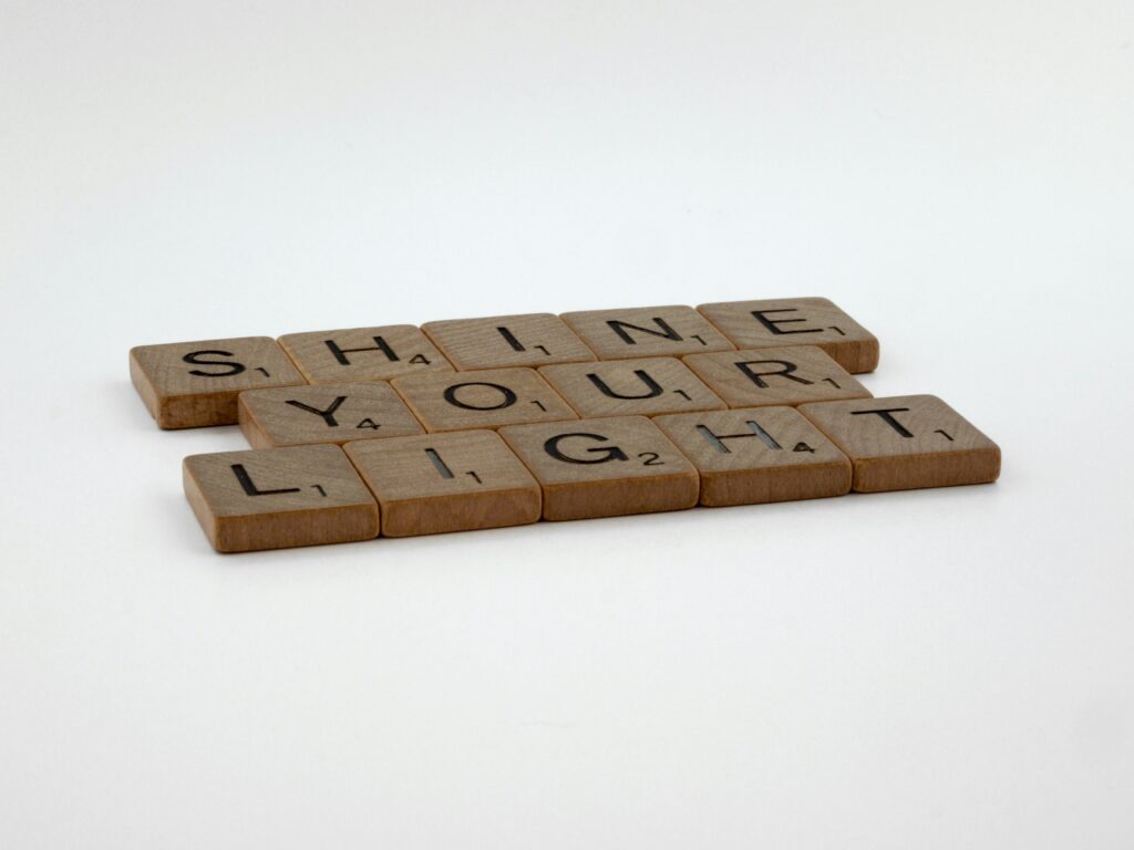 Scrabble tiles that spell out “Shine your light.”