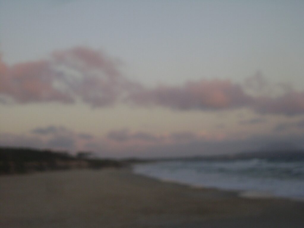 A beach at sunset, slightly out of focus.