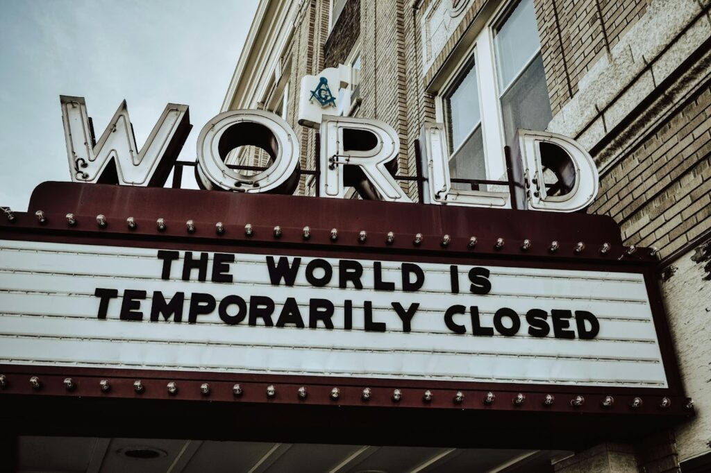 Image of a theatre sign. The theatre is called World, and the sign underneath says in all caps, “The world is temporarily closed.”