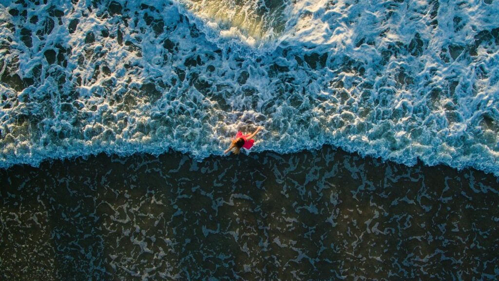 Aerial image of a woman dancing in the ocean