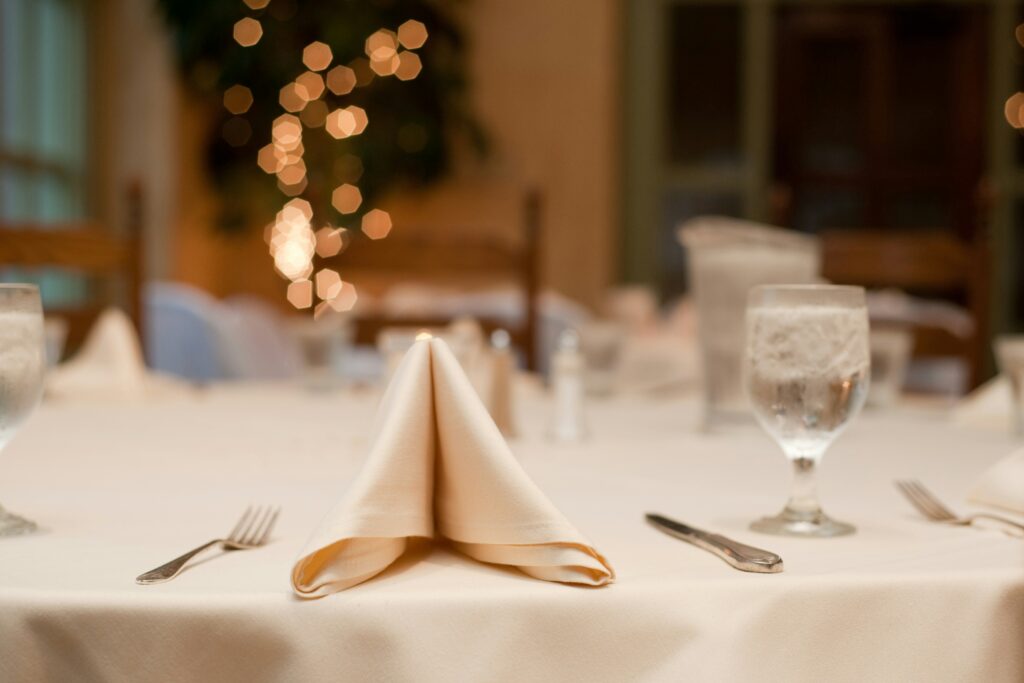 A folded napkin as part of a place setting at a banquet table.