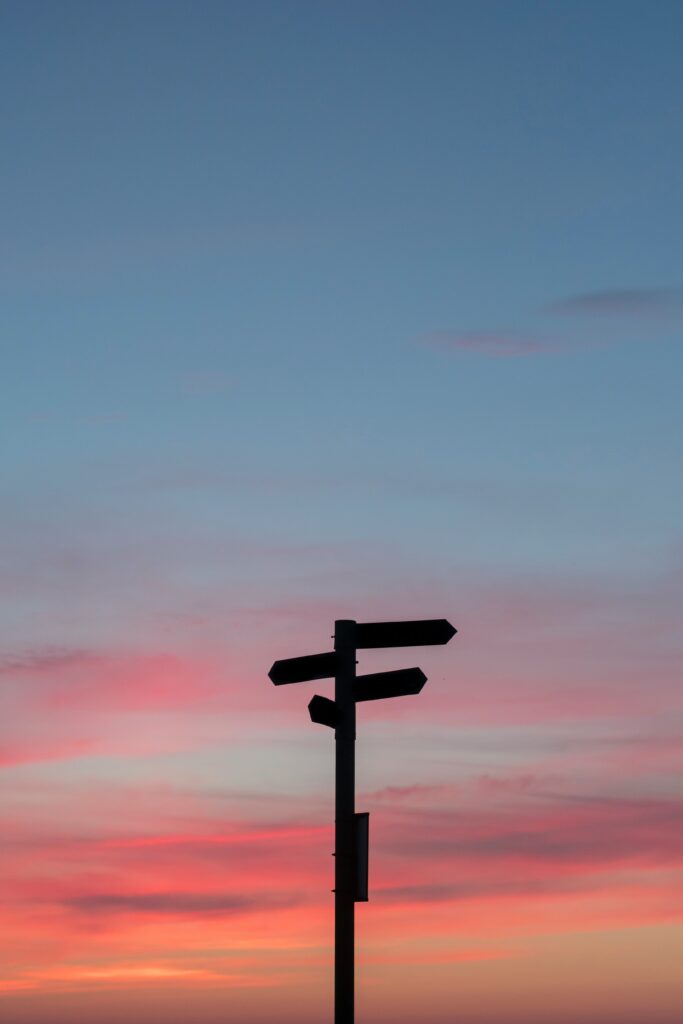 A street sign against a sunset. 