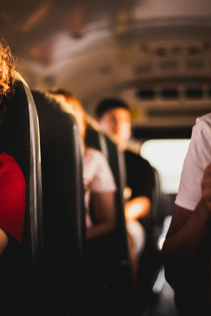 Adolescents riding the school bus on a warm day.