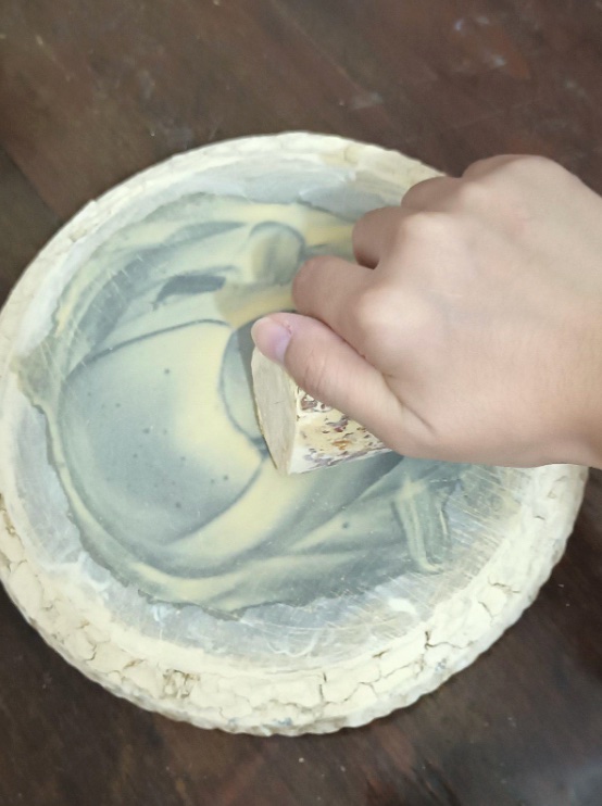 A hand making thanaka.