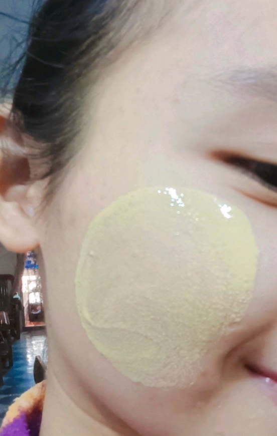 A person wearing thanaka on their cheek.