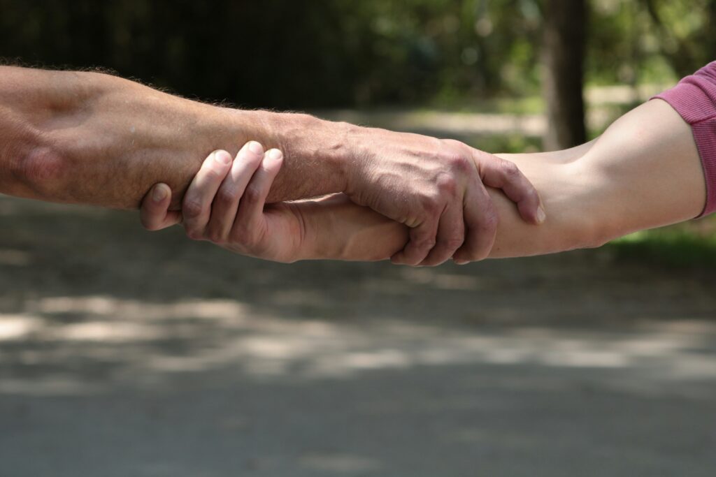 Image of two people grasping each other’s arms.