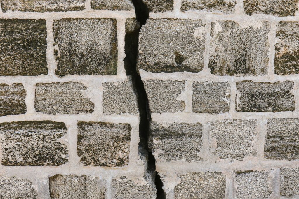 Bricks of a wall, separated by a large crack.