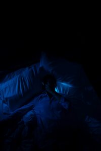A person laying in a bed in a dark room.