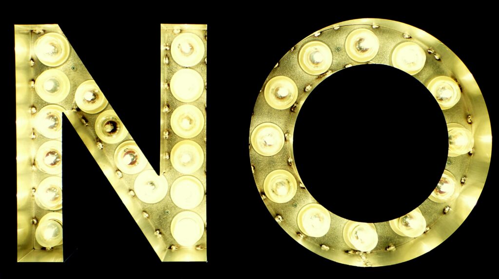  A big sign that reads “NO,” composed of multiple lightbulbs against a black background.