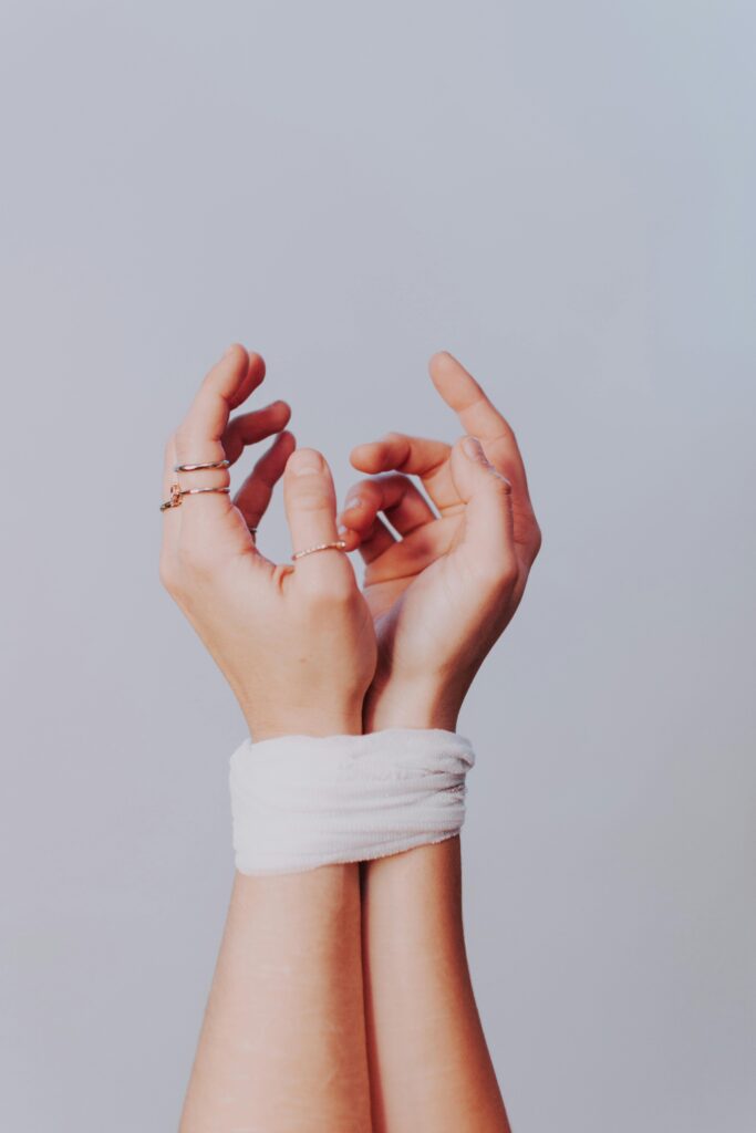 Image of a person's hands tied together with white fabric.