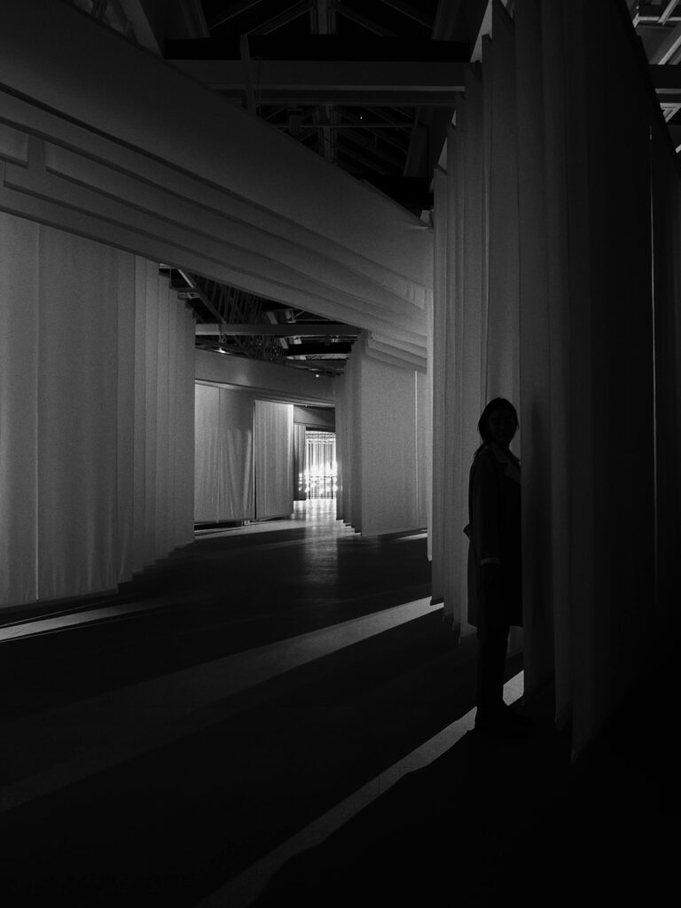 A figure standing in a dark hallway.