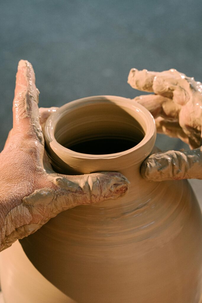 Hands forming a clay pot.