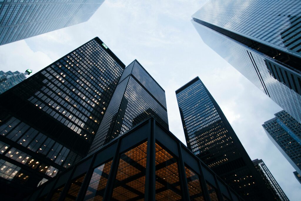 A view of skyscrapers, looking up from the ground.