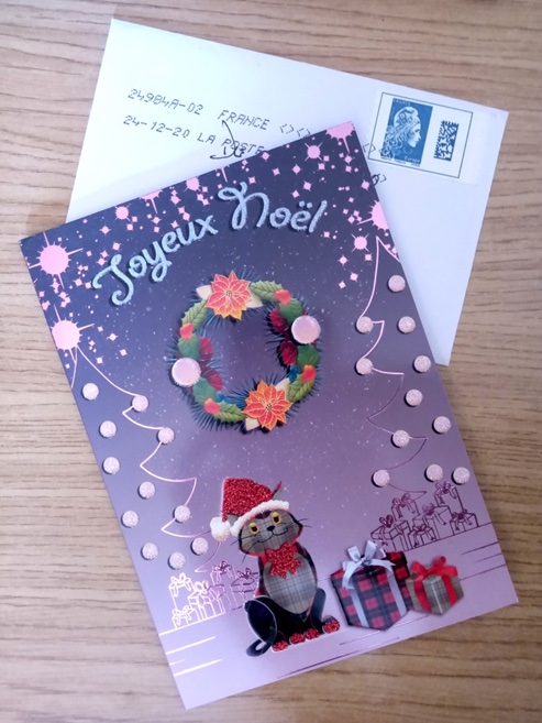 A French Christmas card, featuring a wreath and a black cat. 