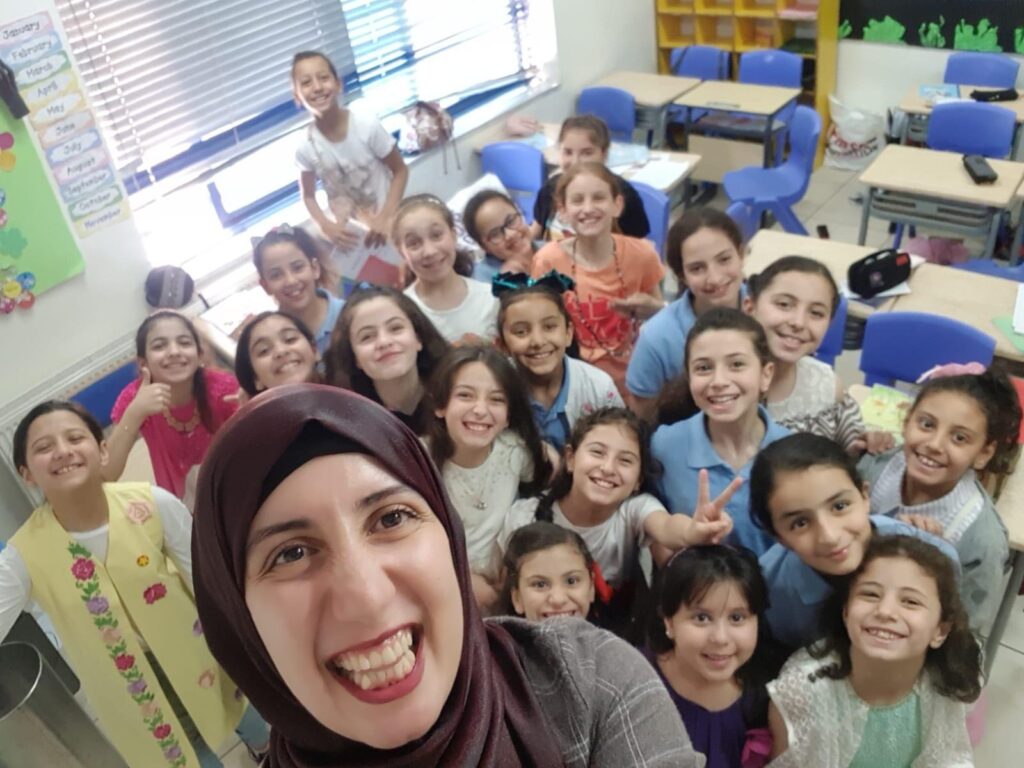 Wiam Najjar and a group of children, all smiling at the camera.