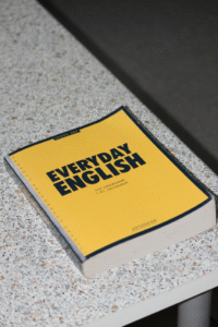 A yellow book titled “Everyday English” sits on a desk