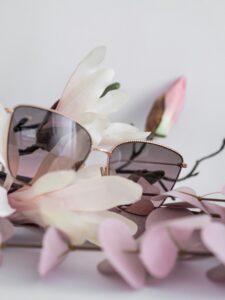 Tinted glasses sitting on white magnolia flowers
