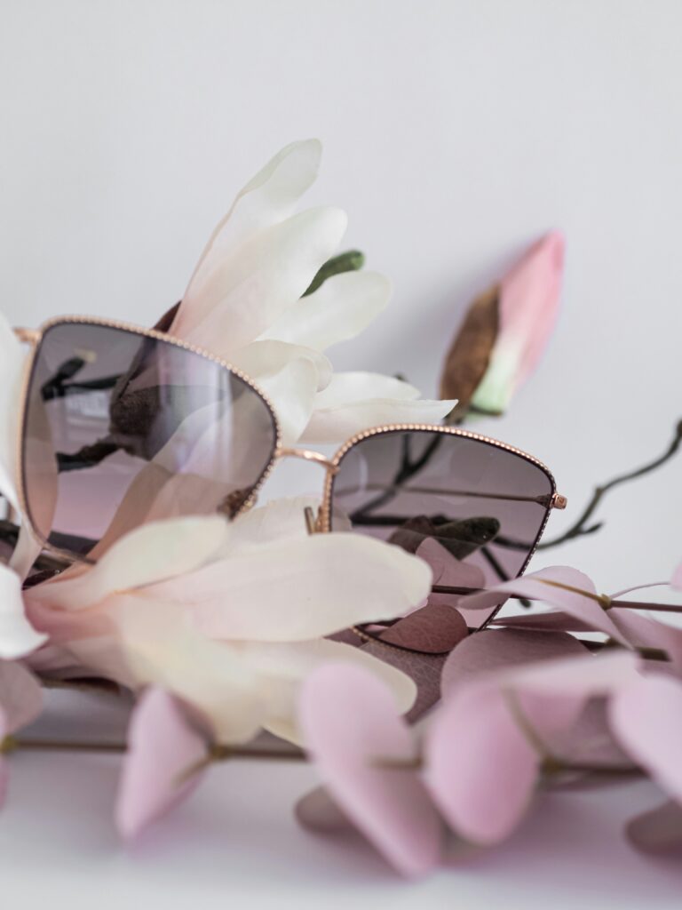 Tinted glasses sitting on white magnolia flowers