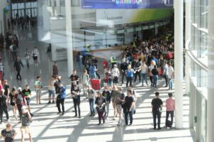People walking along a pathway in a convention center.