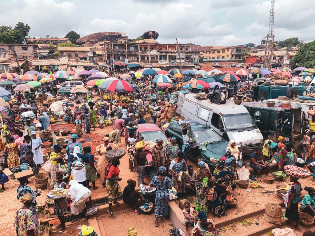 Crowded outdoor marketplace in plaza of shoppers and vendors 