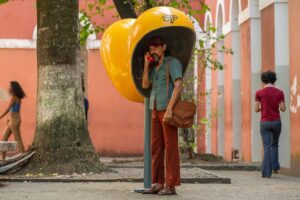 Actor Kaiony Venâncio using a public telephone in a scene from the film The Secret Agent. (Photo: Courtesy of Vitrine Filmes)