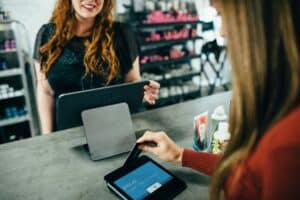 A woman swiping a credit card at the counter.