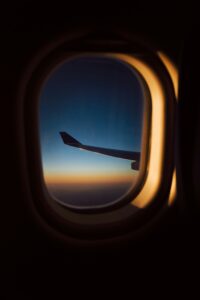 View of the airplane wing above the horizon from a window in-flight.