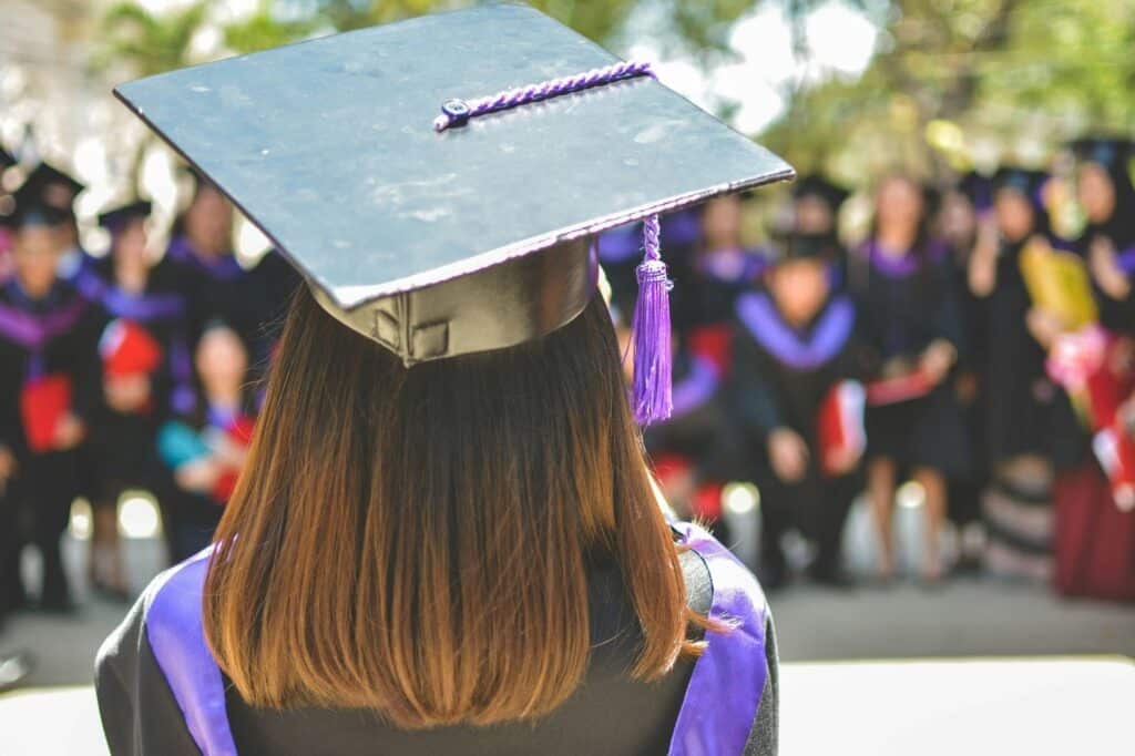 Image of a person in a cap and gown facing away from the camera.