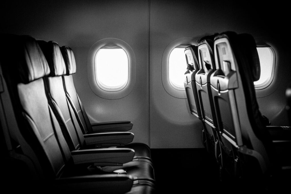 Image of empty airplane seats in greyscale.