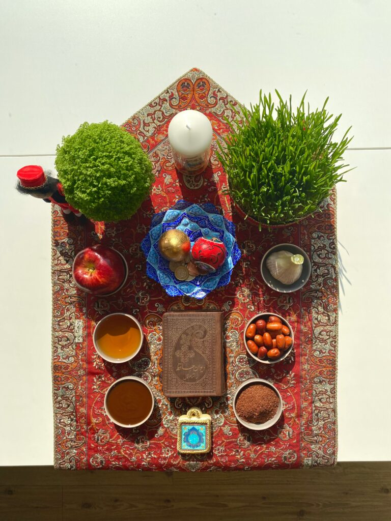 A table topped with bowls of food in honor of Nowruz, the Iranian or Persian New Year’s Day. | Image courtesy of Pouya Jabbarisani via Unsplash