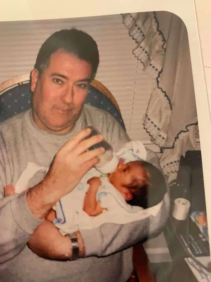 A 56-year-old Grampy holding his infant granddaughter.