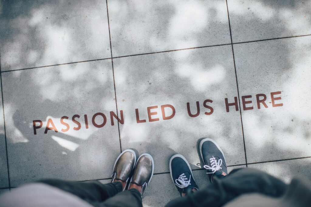 Two people standing on gray paving with text saying, "Passion led us here." 