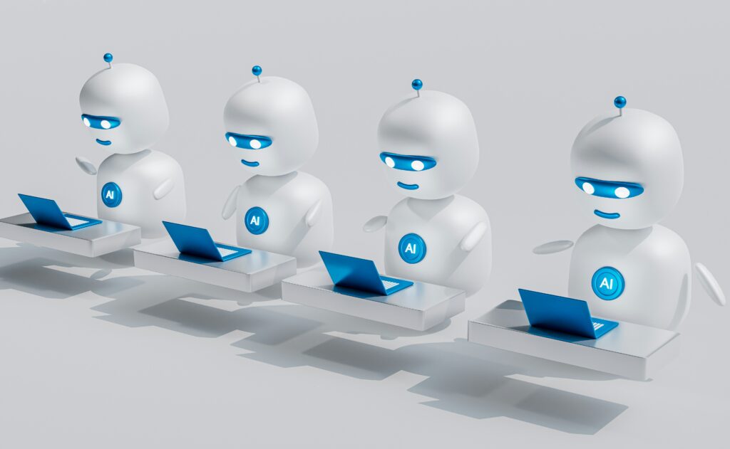 A group of four white robots sitting on top of blue laptops.