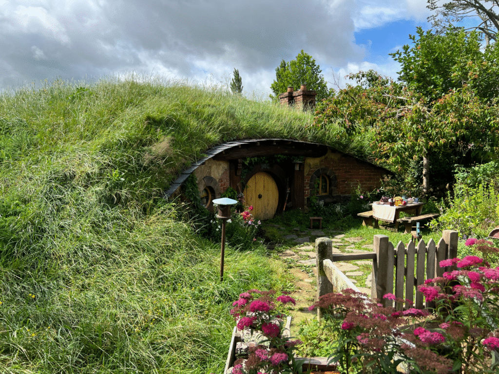 A yellow door Hobbit hole with a picnic table out front.