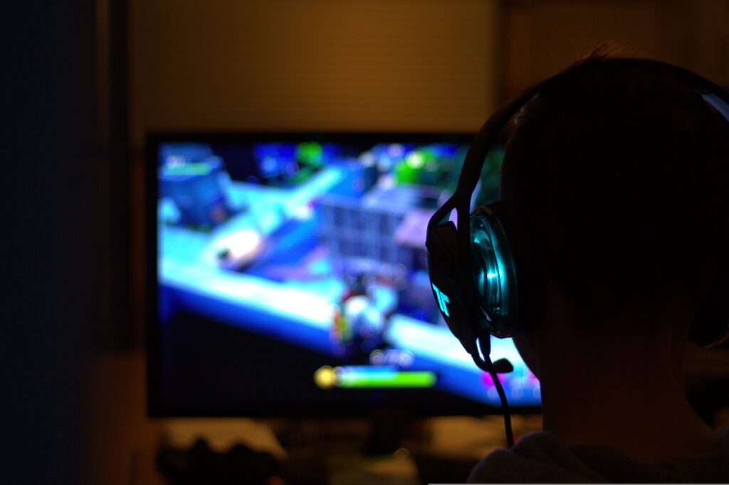 Person playing a computer game in the dark.