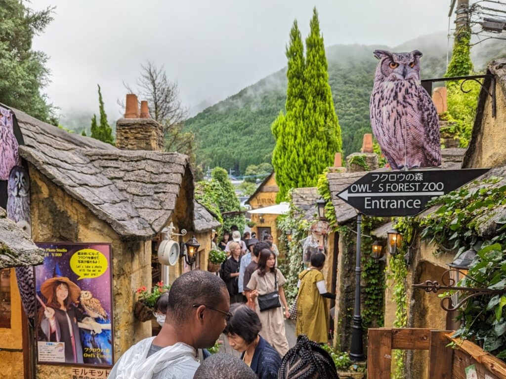 An image of a small flower village full of trees, shops and tourists.