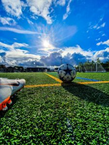 The sun shines on a blue and white football with start on it,