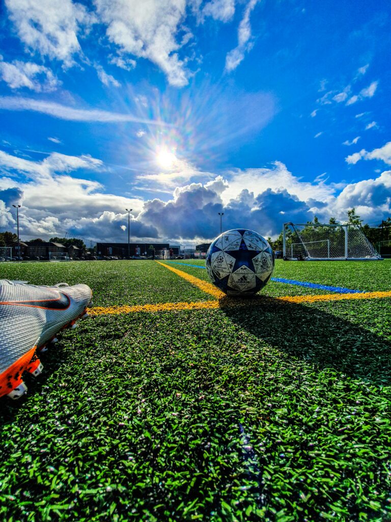 The sun shines on a blue and white football with start on it,