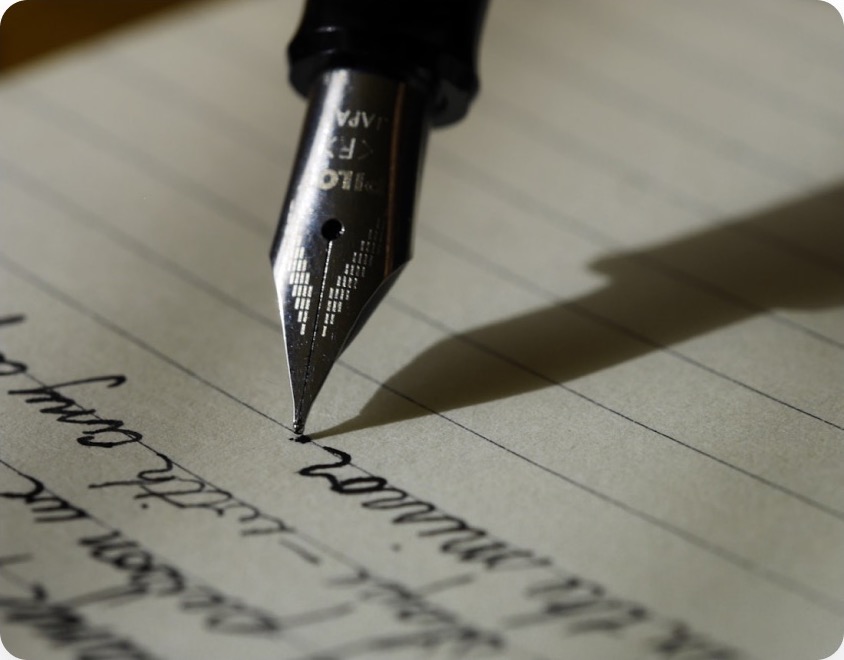 A fountain pen resting on handwritten pages
