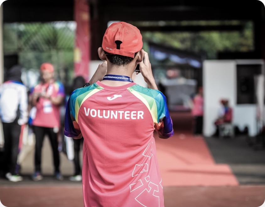 A volunteer in a branded shirt at an event